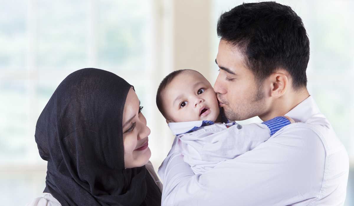 multicultural parents kissing baby